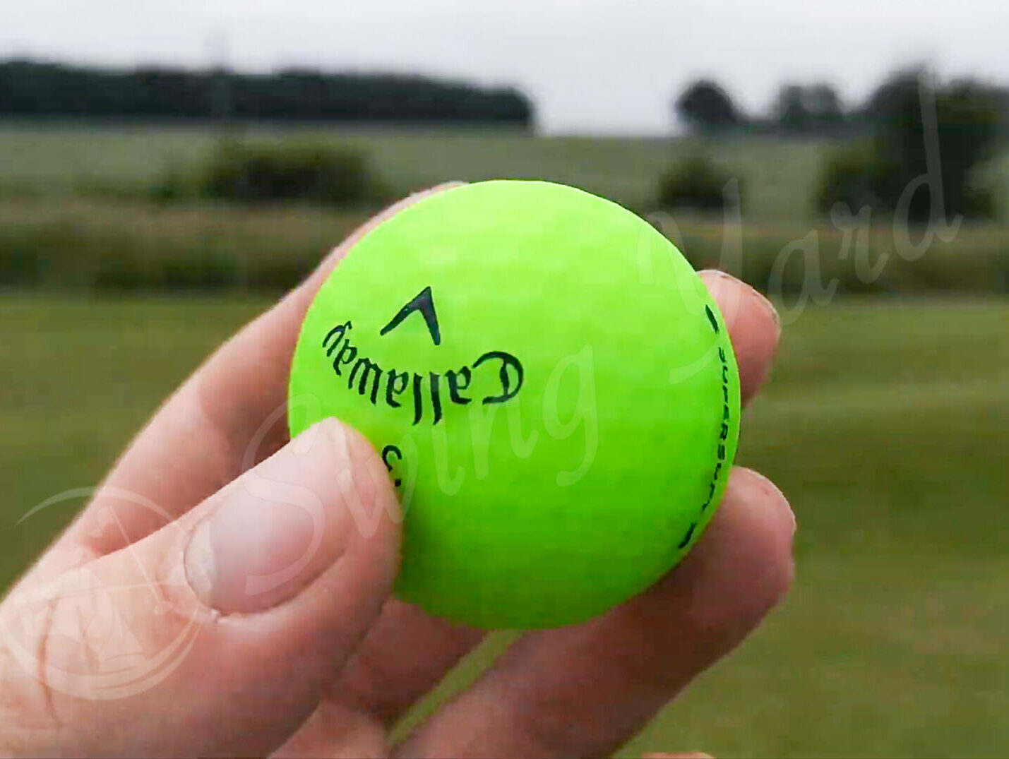 A Callaway Supersoft green ball in my hand at the golf course
