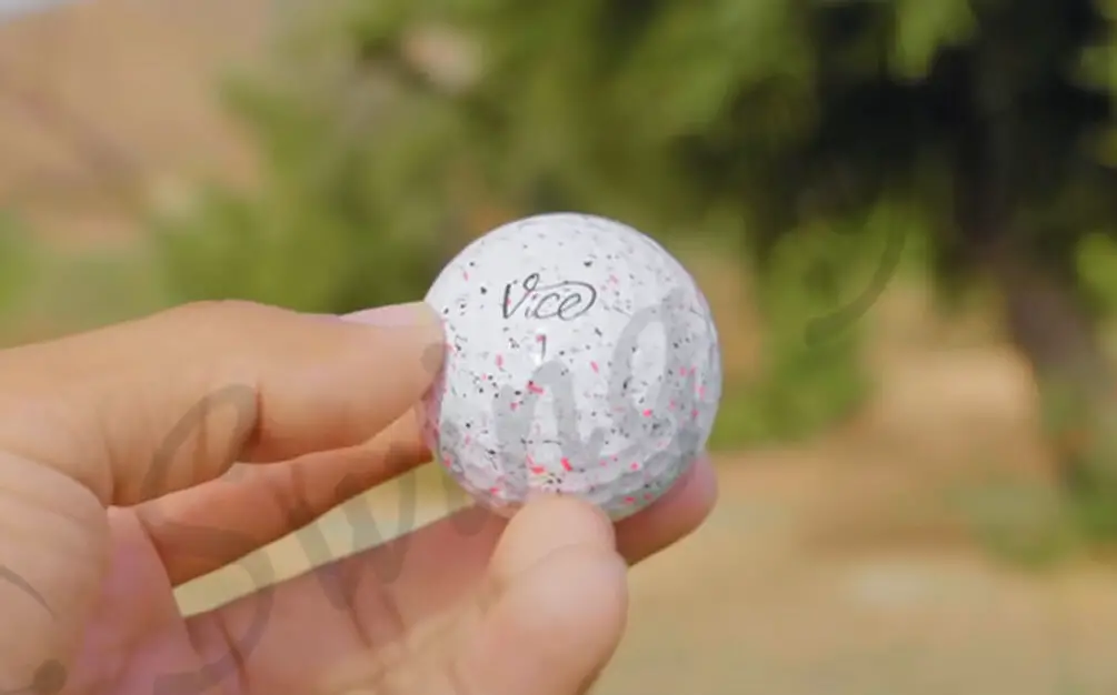 Me holding a white Vice Pro Soft ball for testing at the golf course