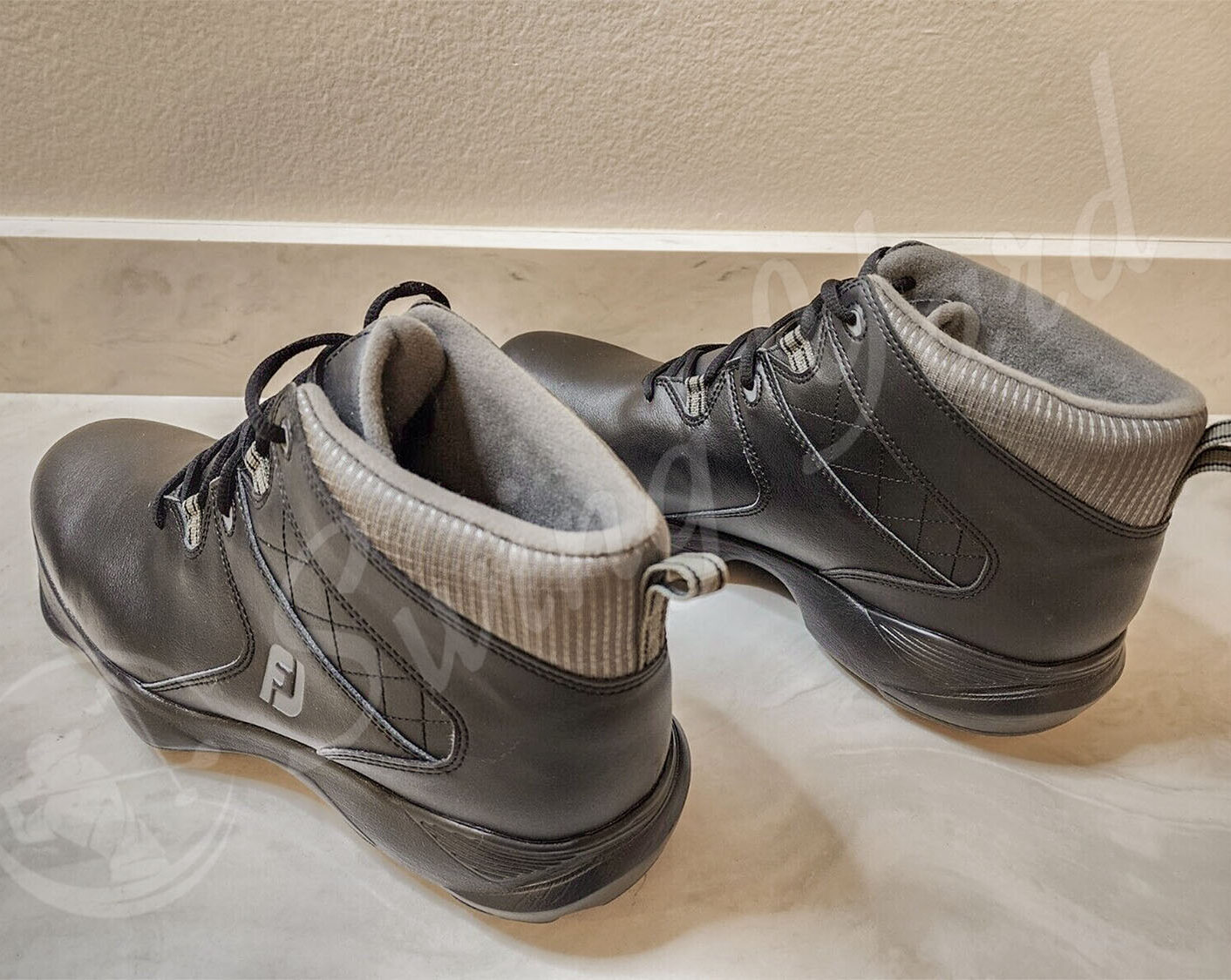 A pair Footjoy cascade spiked golf Boots on the floor