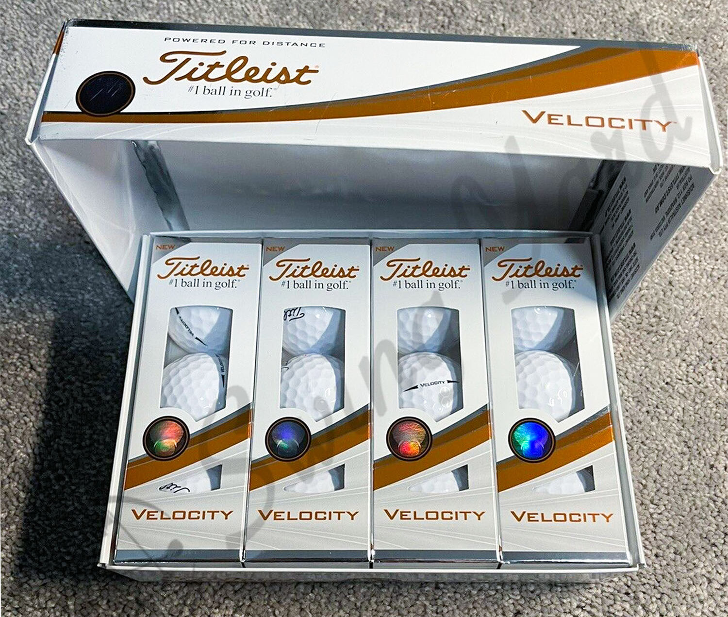 The 4 single packs inside of Titleist Velocity box on the floor