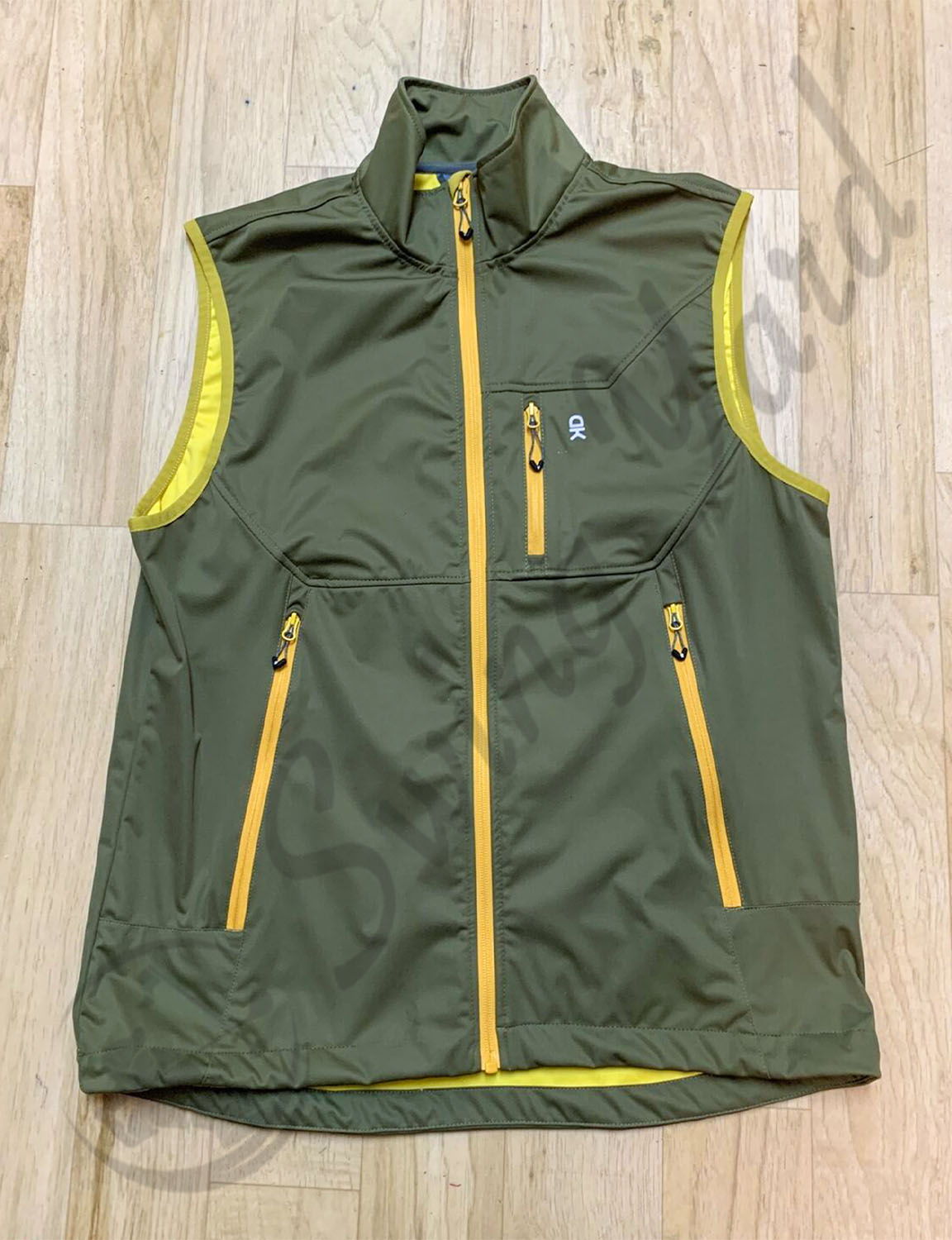 A Olive green Little donkey andy men lightweight softshell vests in the floor