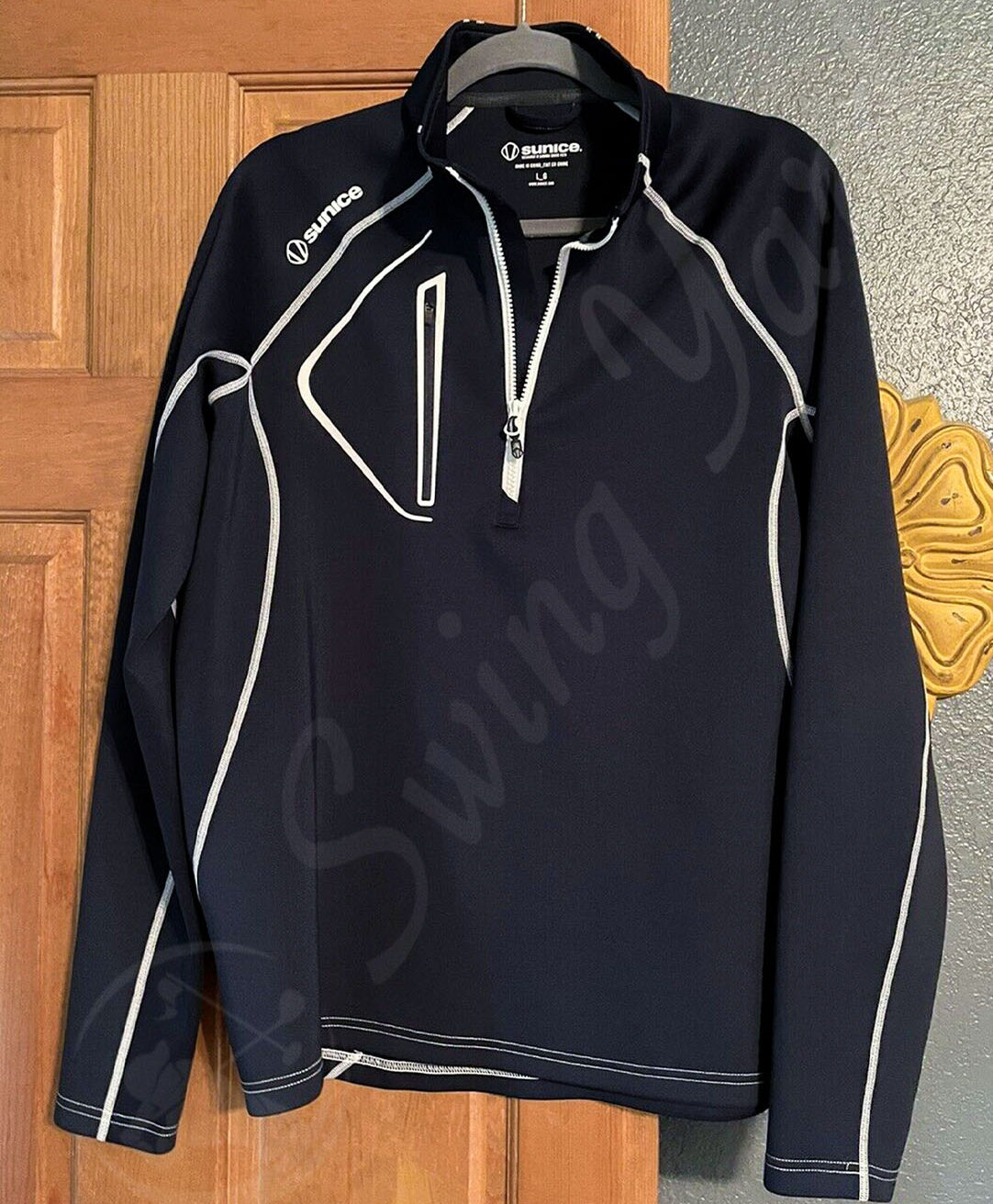 A black Sunice allendale men’s thermal golf jacket pullover hang on the door