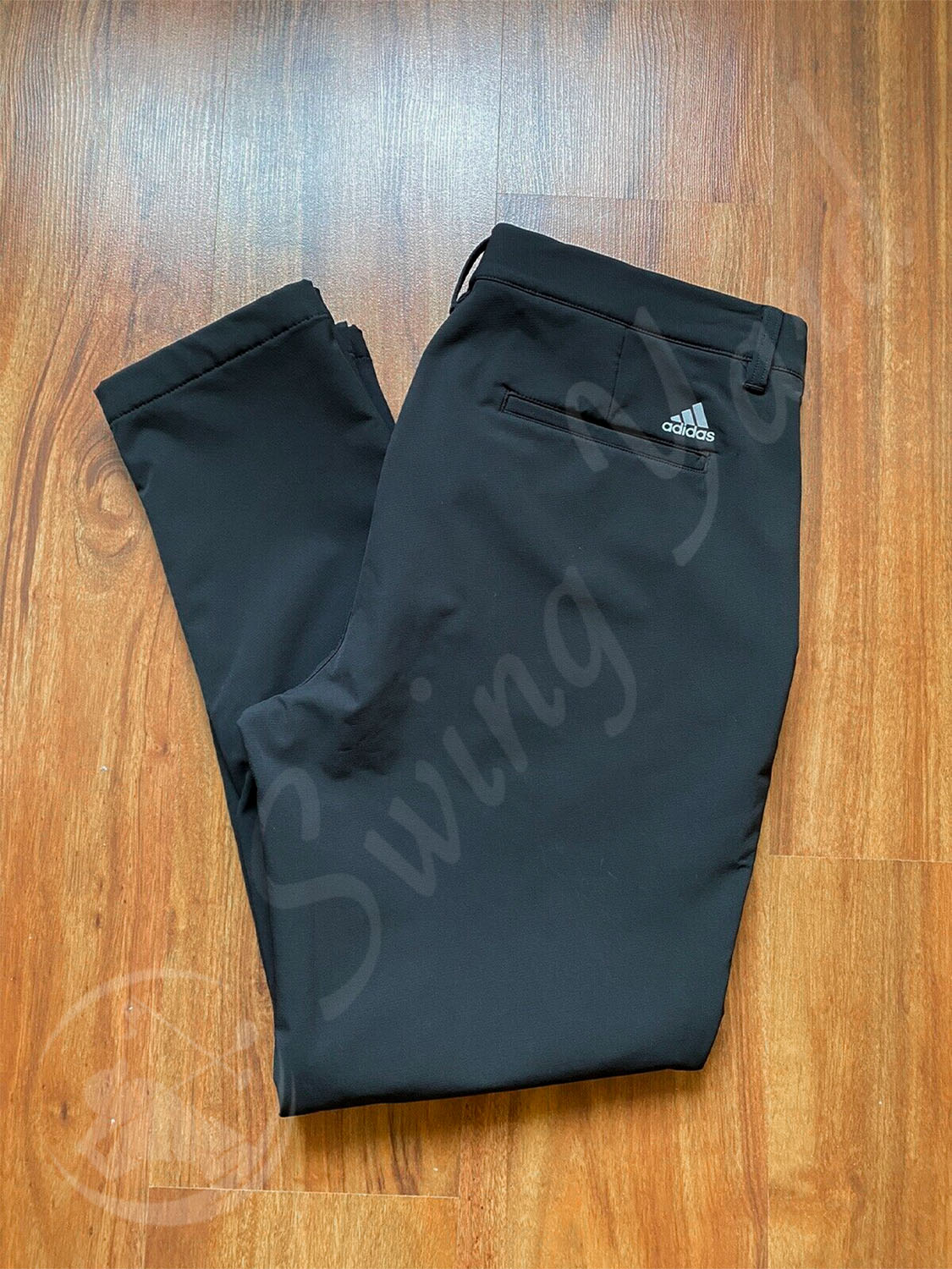 A folded Adidas men frostguard insulated pants at the floor