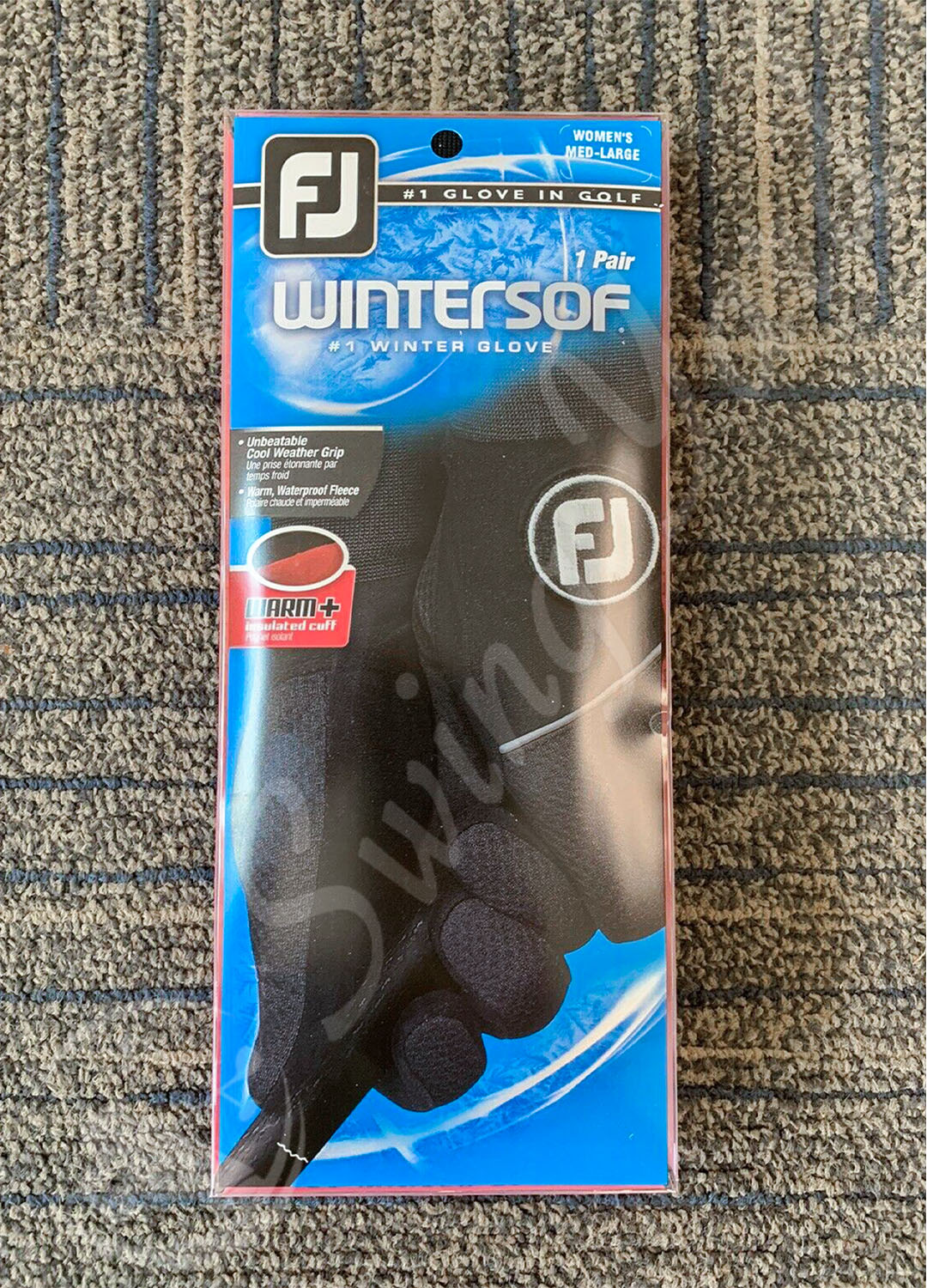 A frontside view of FootJoy women winter sof golf gloves pack on the floor