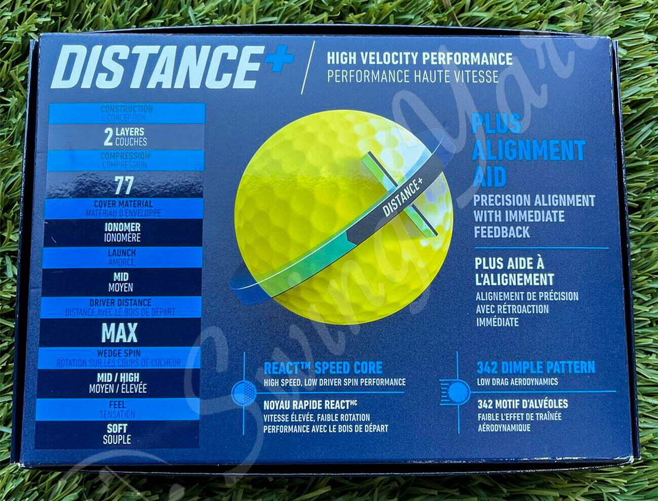 A yellow green TaylorMade Distance Plus box in the grass