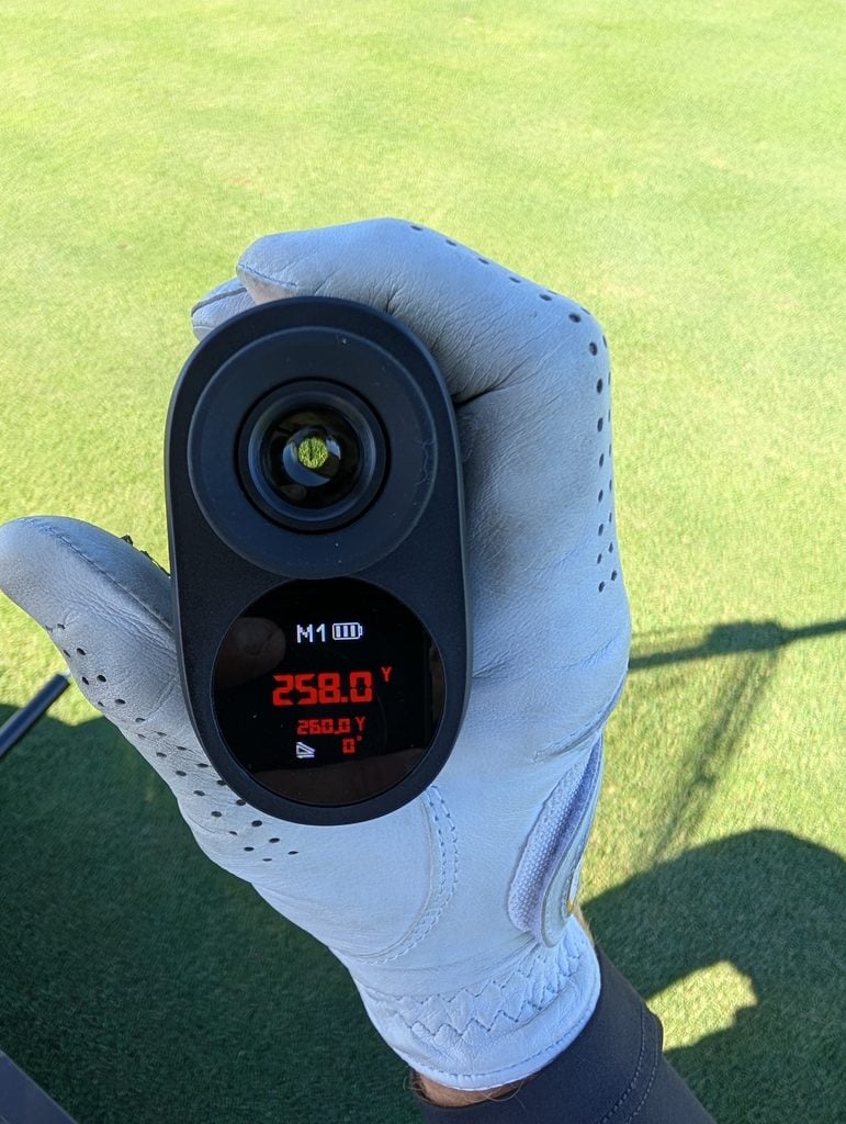 Image of the golf Minener G303 Range Finder showing the distance to the flag stick with a little bit of slope adjustment.