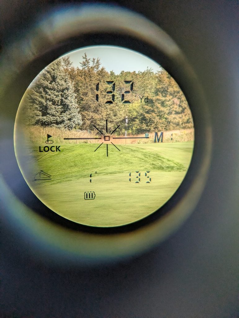 A look through the lens of the Minener G303 Range Finder where you can see the flag, distance and slope adjustments.
