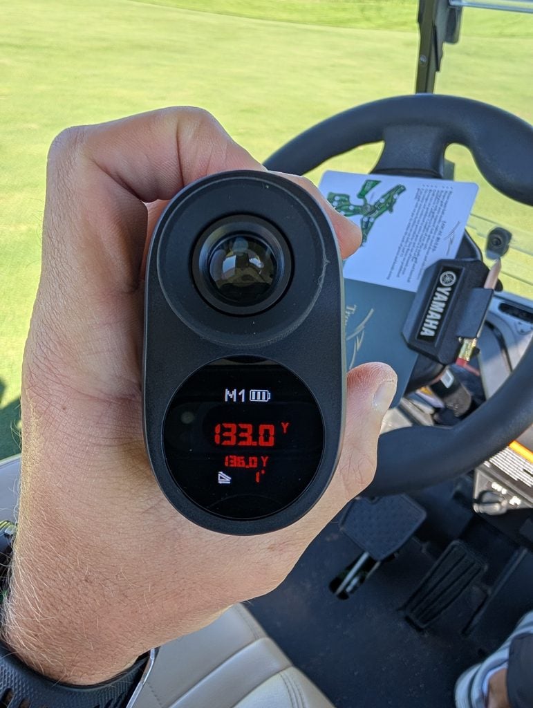 The Minener G303 Golf Range Finder showing the yardage and slope on the golf course