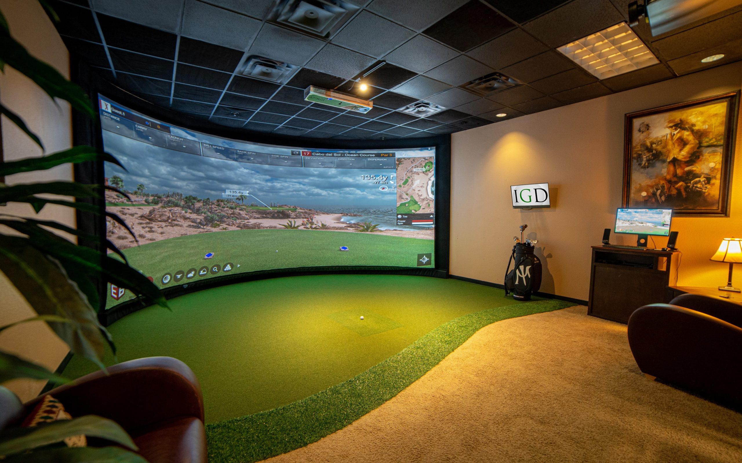 An ideal golf simulator setup with a nice projector, impact screen and hitting mat.