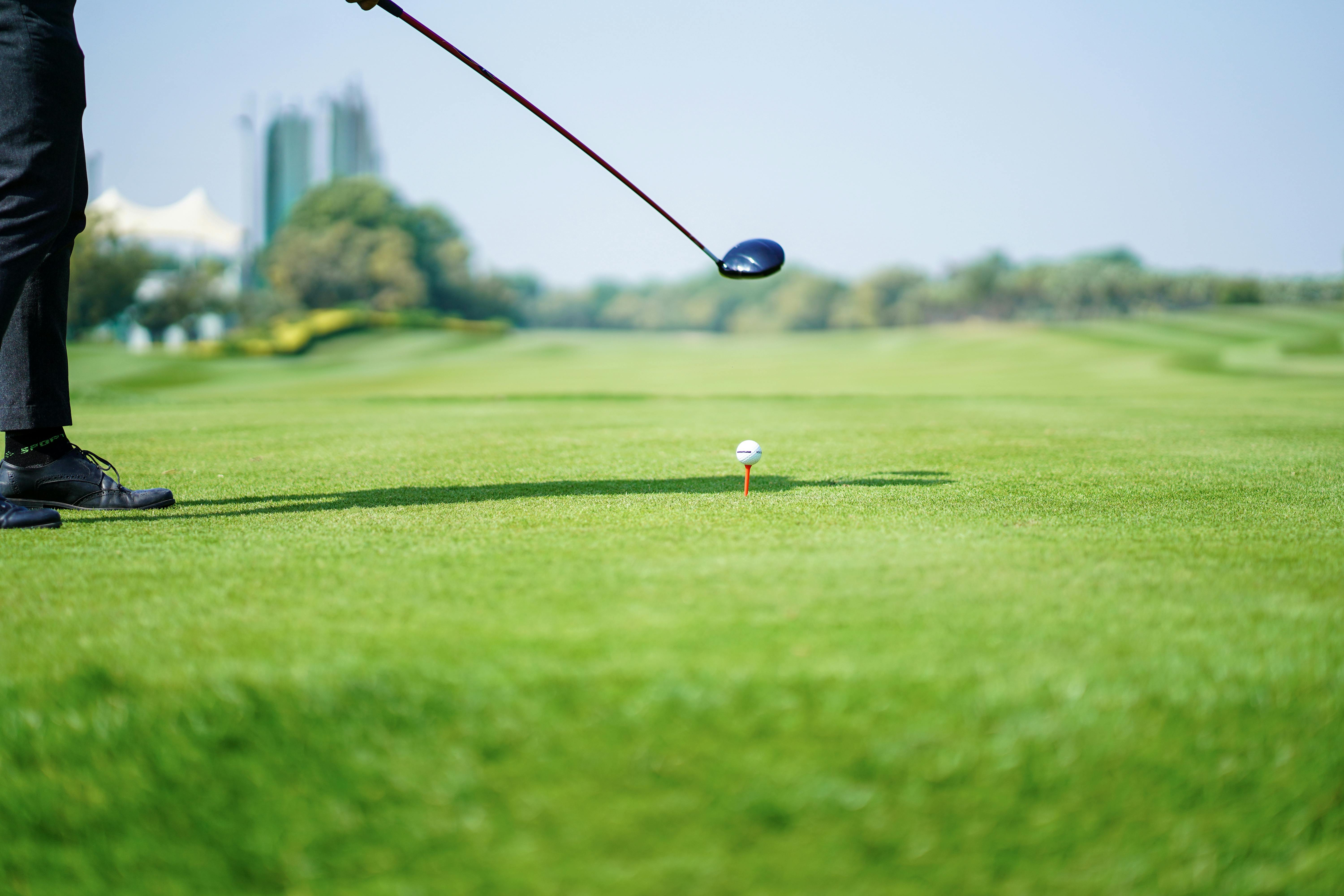 a golfer addresses the golf ball at the tee box with his driver