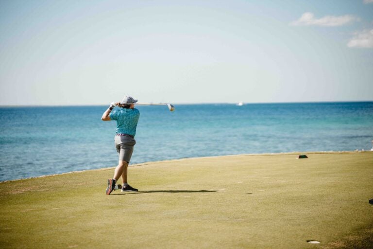 golfer on the tee box swinging at his driver