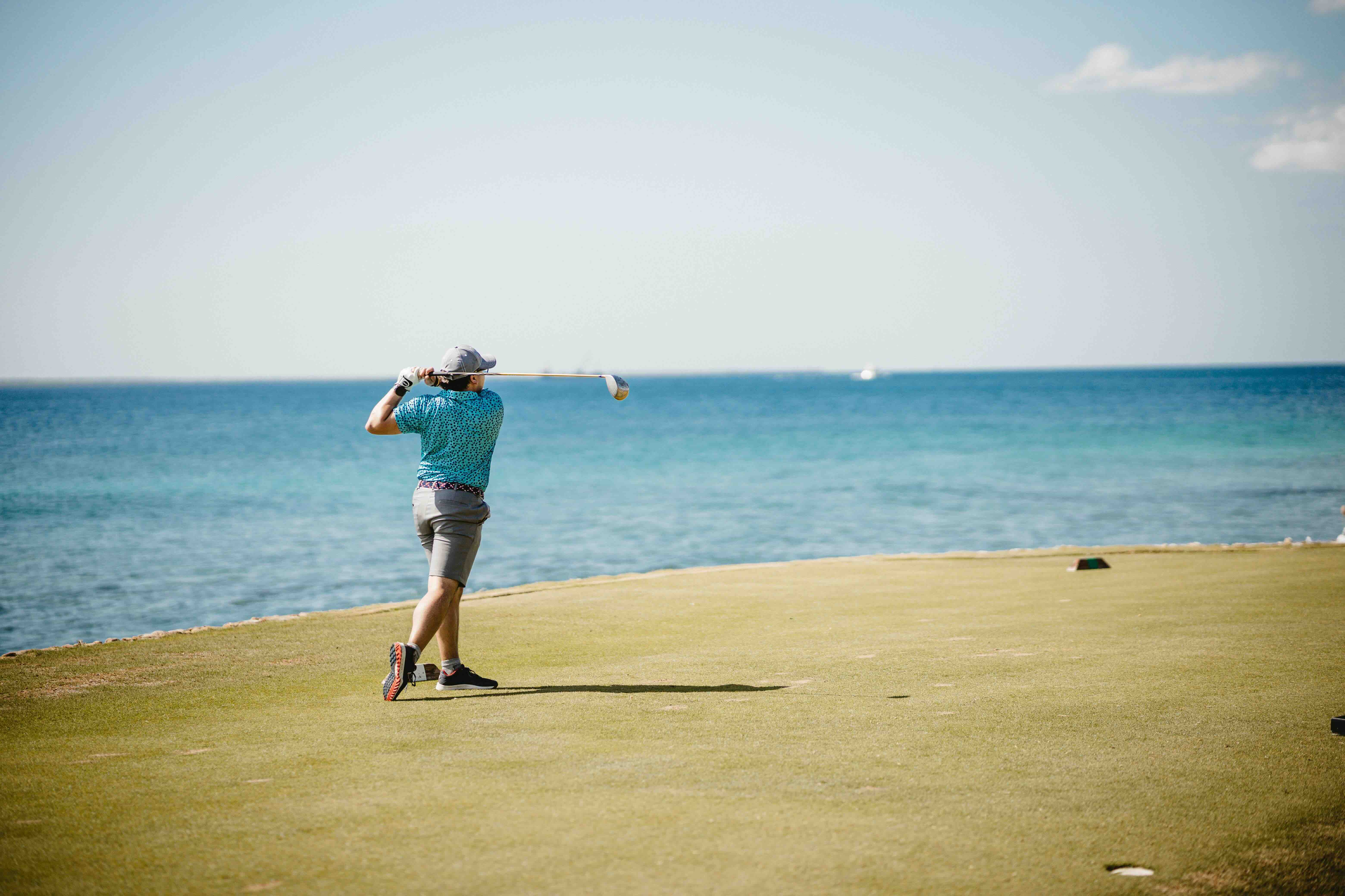 golfer on the tee box swinging at his driver