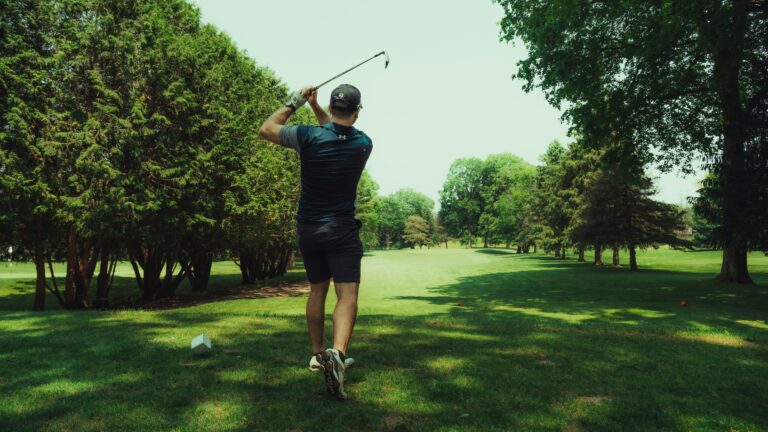beginner golfer completing his swing off the tee box