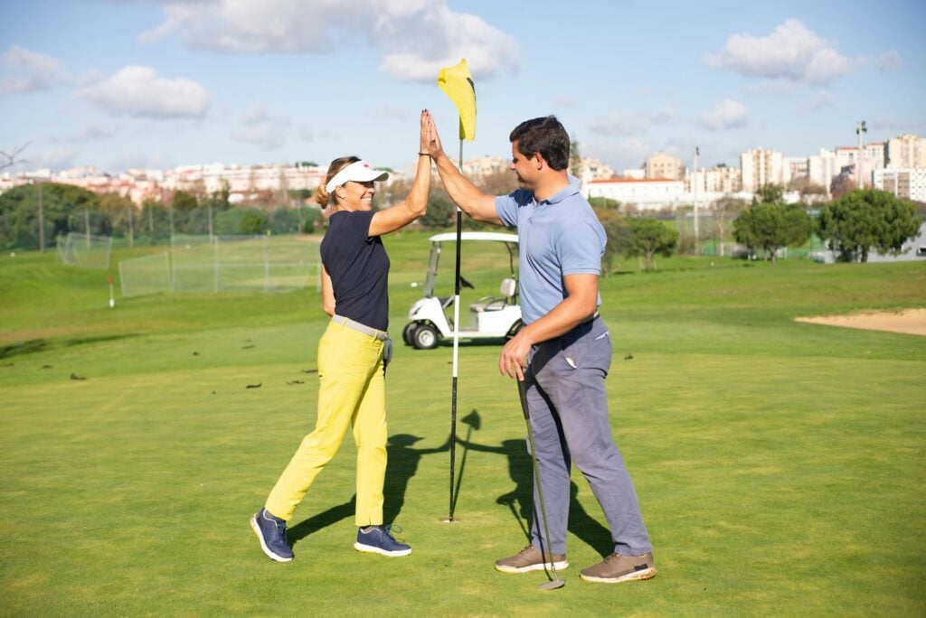 Golfers having fun playing golf and highfiving each other after a fun round of stableford scoring