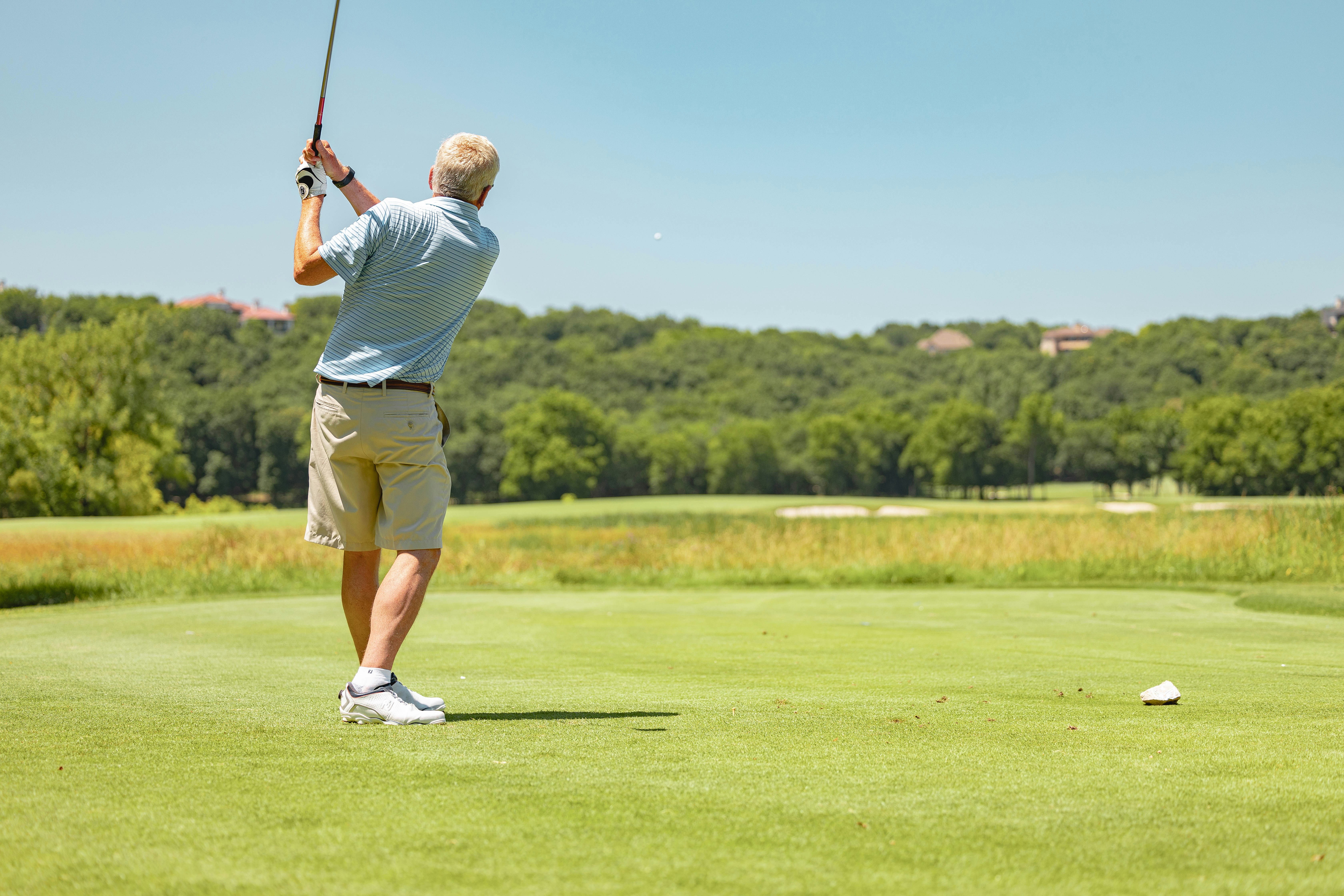 senior golfer practicing his swing to improve